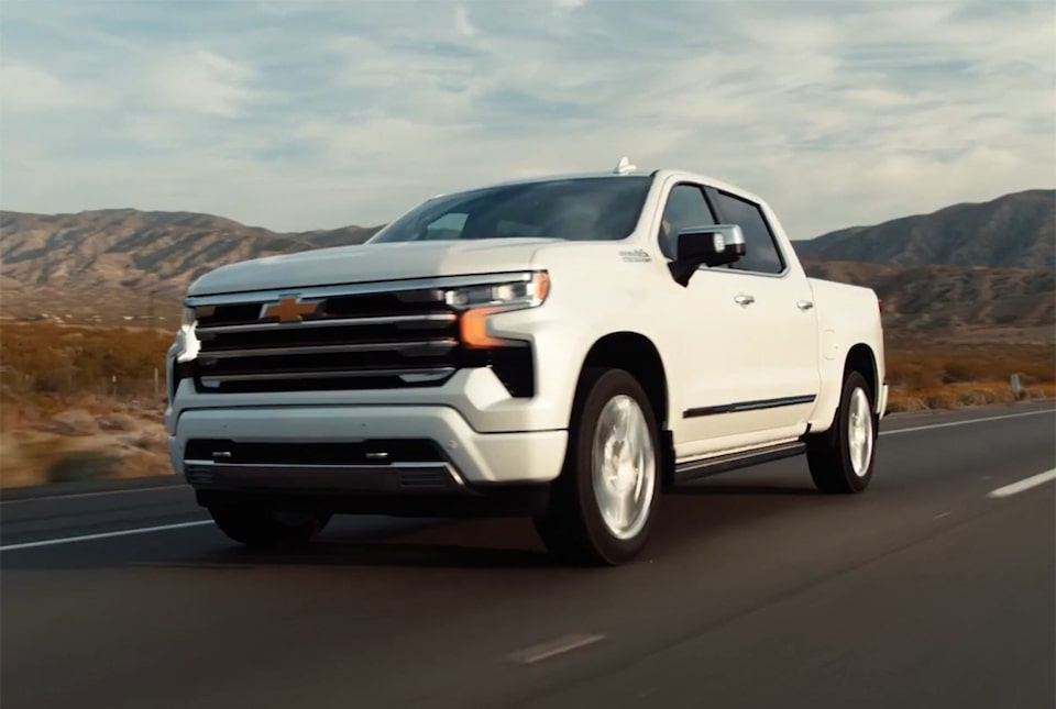 Imagem da picape Chevrolet Silverado High Country branco summit em uma estrada de asfalto.