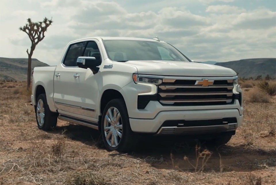 Imagem da picape Chevrolet Silverado High Country, branco summit de perto, em um campo de terra.
