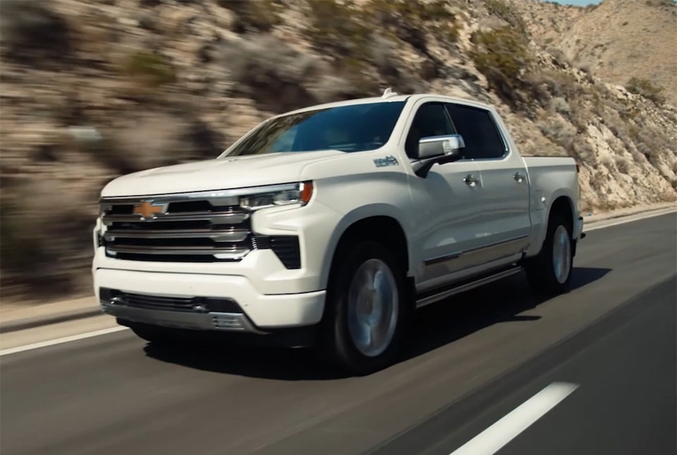 Imagem da picape Chevrolet Silverado High Country branco summit em uma estrada de asfalto.