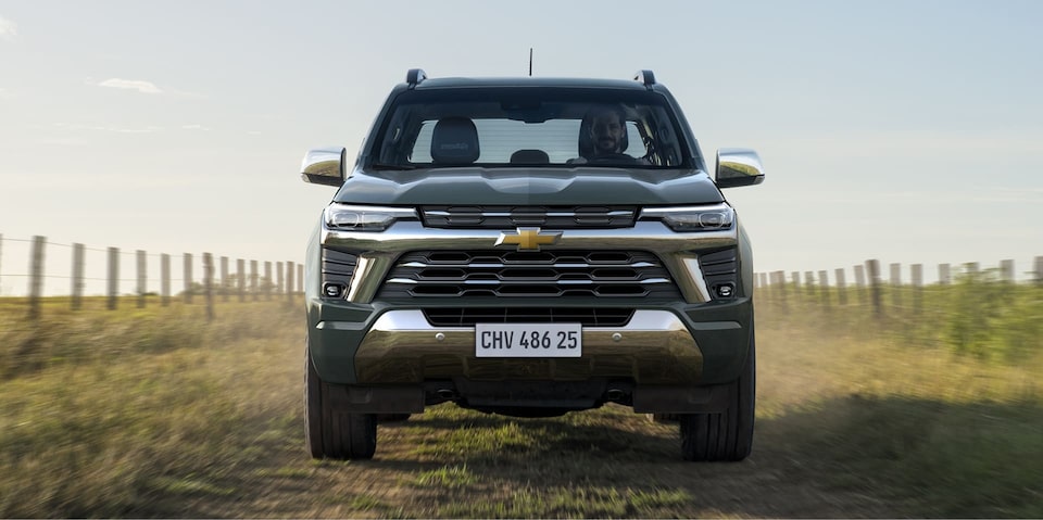 Frente da nova S10 Chevrolet, na cor cinza moss, parada em área rural