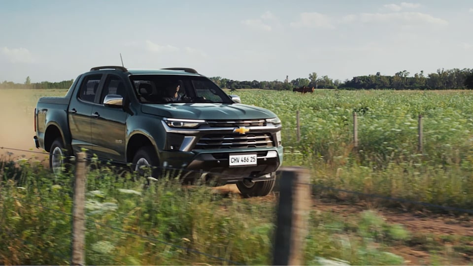 Nova S10 na cor cinza moss andando em estrada de terra, em uma paisagem rural