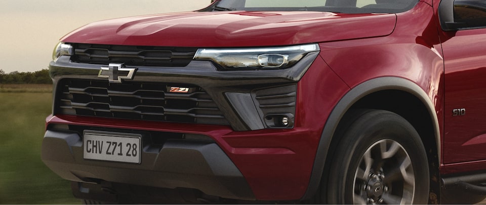 imagem frontal da Chevrolet s10 na cor vermelha, mostrando faróis e grade
