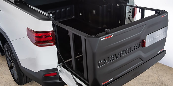 O extensor de caçamba possui suporte de placa com iluminação, carenagem externa personalizada e se transforma em uma escada/rampa ou em um divisor de carga para a sua Nova Chevrolet Montana 2023.