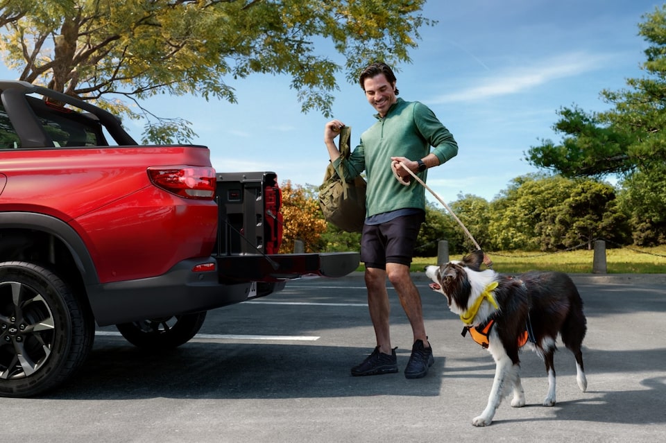 Homem na frente de uma picape Chevrolet segurando o cachorro pela coleira, representando os acessórios de pet da Chevrolet