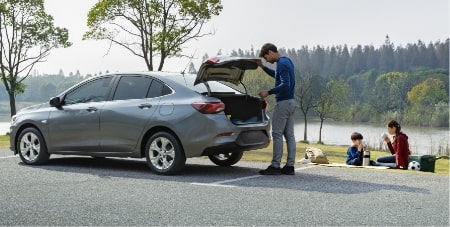 Imagem de um homem abrindo o porta malas de um carro Chevrolet