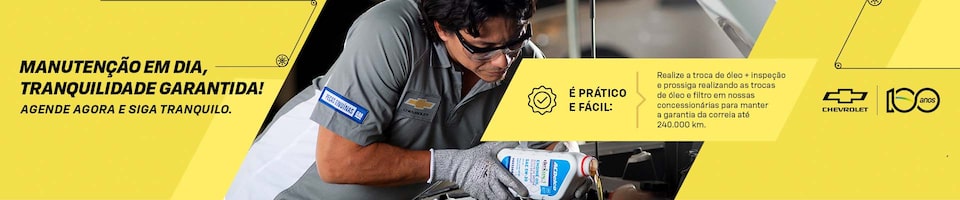 Banner da campanha de manutenção Chevrolet destacando a importância da troca de óleo e inspeções periódicas para manter a garantia do veículo. A imagem mostra um mecânico realizando o serviço em uma concessionária autorizada. Mensagem reforça praticidade, segurança e tranquilidade ao manter a manutenção em dia.
