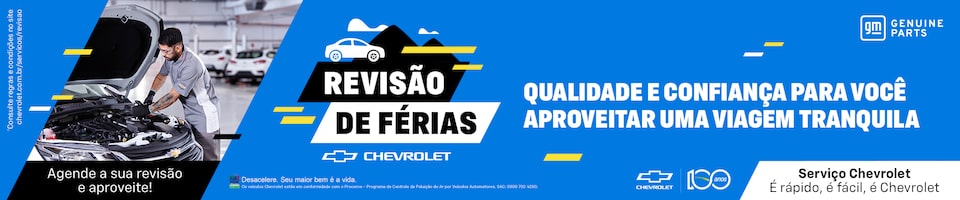 Mecânico Chevrolet realizando inspeção no motor de um carro em oficina. Texto no centro: “Revisão de Férias Chevrolet”. Ao lado, mensagem: “Qualidade e confiança para você aproveitar uma viagem tranquila”