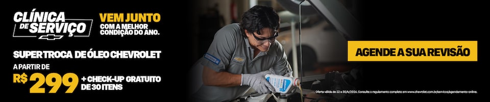 Um banner sobre a clínica de serviço Chevrolet. Do lado direito da imagem, temos um mecânico colocando óleo no reservatório do motor. Ele usa óculos de proteção, luvas e vemos o logo da Chevrolet em sua camisa. Do lado direito, temos os textos: Clínica de Serviço, vem junto com a melhor condição do ano, Super troca de óleo Chevrolet. A partir de R$ 299, mais check-up gratuito de 30 itens, e um botão clicável, escrito: agende sua revisão. Do lado inferior direito, temos o logo da Chevrolet e o texto: serviço personalizado.