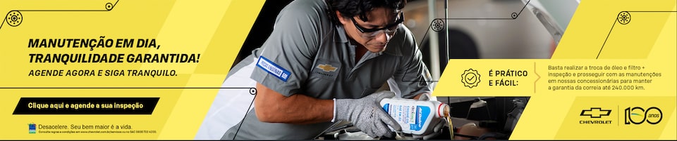 Um banner falando sobre a a importância da manutenção do seu Chevrolet. A imagem está divida em duas: do lado direito da imagem, temos um mecânico usando óculos de proteção enquanto coloca óleo no veículo. Do lado esquerdo, em um fundo amarelo, temos os textos: Manutenção em dia, tranquilidade garantida! Agende agora e siga tranquilo. É prático e fácil: basta realizar a troca de óleo e filtro mais inspeção e prosseguir com as manutenções em nossas concessionárias para manter a garantia da correia até 240 mil quilômetros. E abaixo, destacado em preto, o texto: clique aqui e agende sua inspeção.