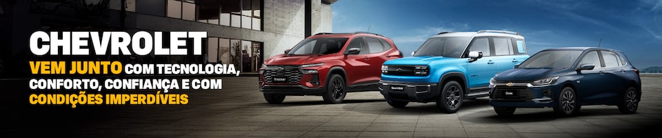 Três carros Chevrolet (Tracker, Spark EUV e Onix) estão estacionados lado a lado em uma moderna praça ao ar livre com textos promocionais sobre tecnologia e condições especiais em português acima deles.