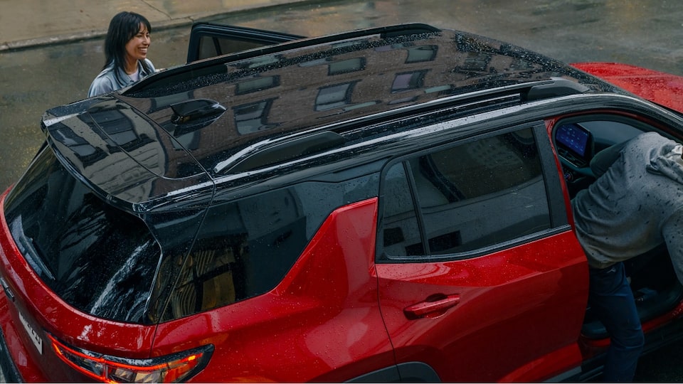 Duas pessoas estão entrando em um Chevrolet Equinox RS Vermelho Radiant.