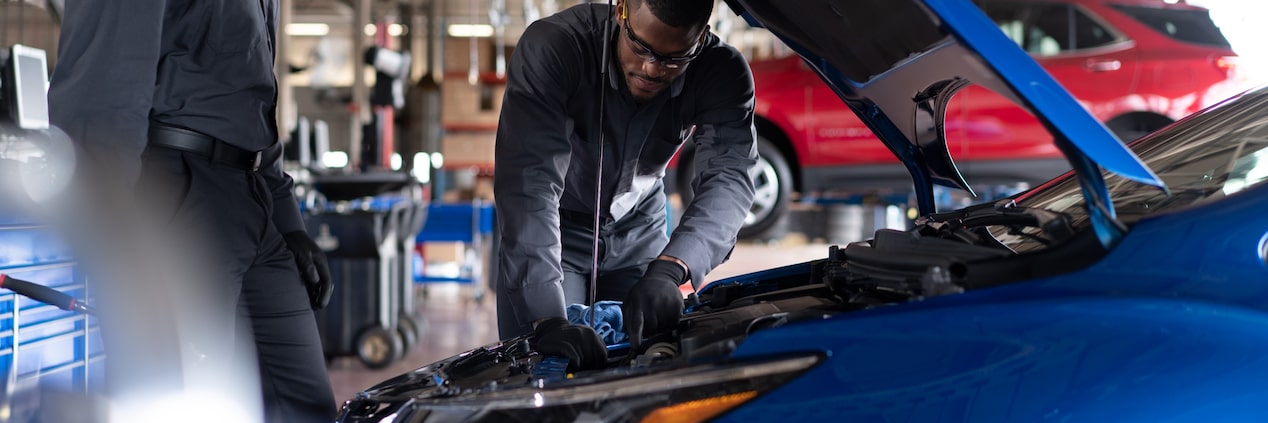 Um mecânico examinando a correia de um Chevrolet.