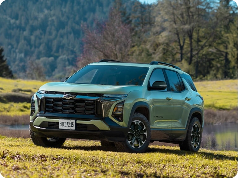 Chevrolet Equinox Verde Cacti estacionado em um campo aberto. Ao fundo, temos árvores e um rio.