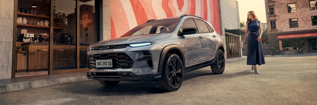 Novo Chevrolet Sonic 2027 SUV cupê cinza em frente a cafeteria moderna com mural urbano
