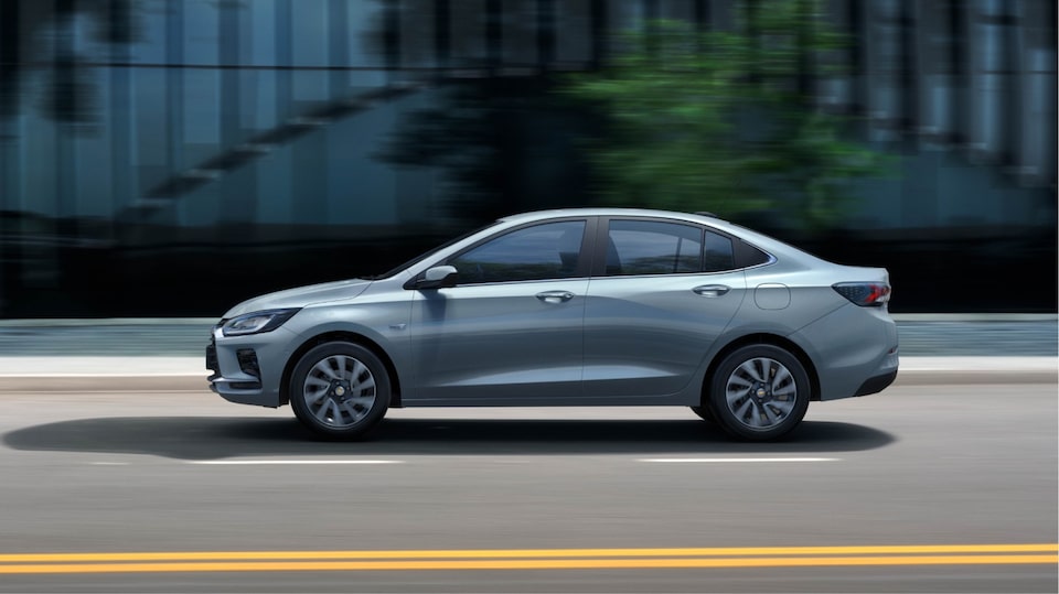 Chevrolet Onix elegantemente estacionado em imagem ambientada na cidade.