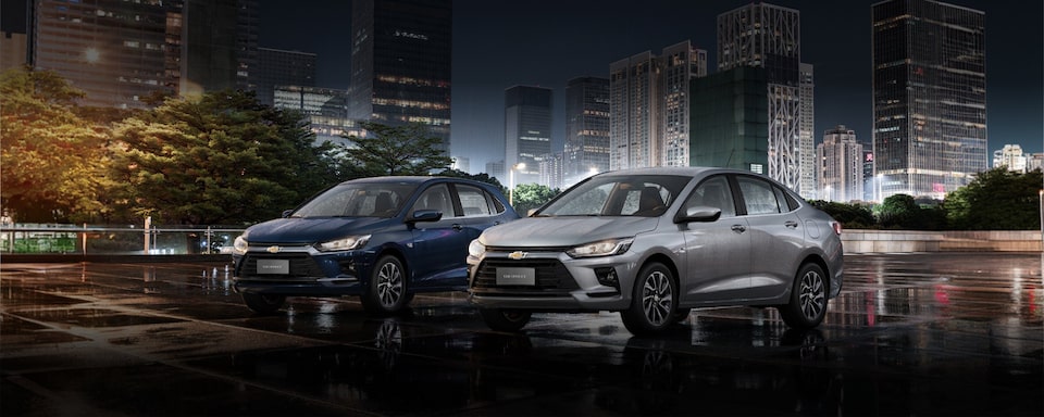 Portfólio de hatches e sedans Chevrolet ilustrado por Onix e Onix Plus dispostos em imagem ambientada com prédios espelhados compondo o segundo plano.