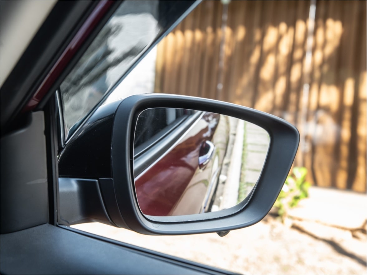 Detalhe retrovistor do passageiro de um Chevrolet Onix Plus para ilustrar a página de acessórios originais Chevrolet desenvolvida para o respectivo modelo.