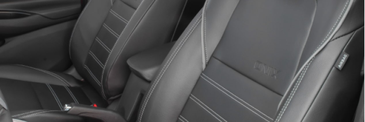 Detalhe dos bancos do motorista e do passageiro do Chevrolet Onix para ilustrar a página de acessórios originais Chevrolet desenvolvida para o respectivo modelo.