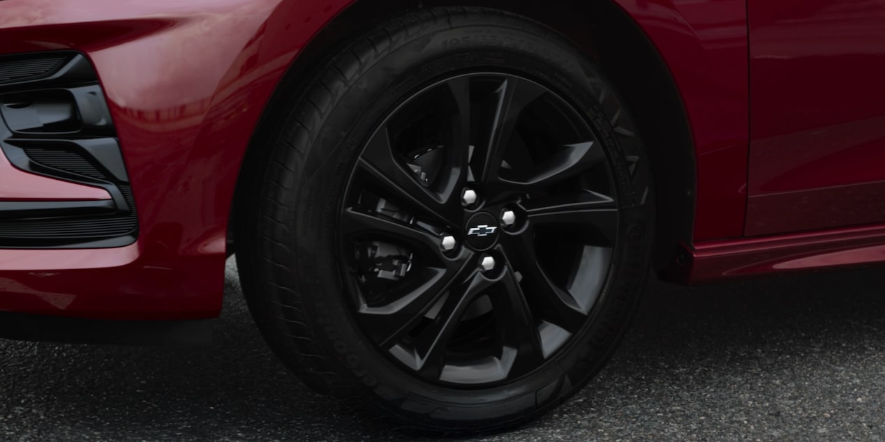 Roda esportiva preta do Onix HB  vermelho Chevrolet com pneu em destaque