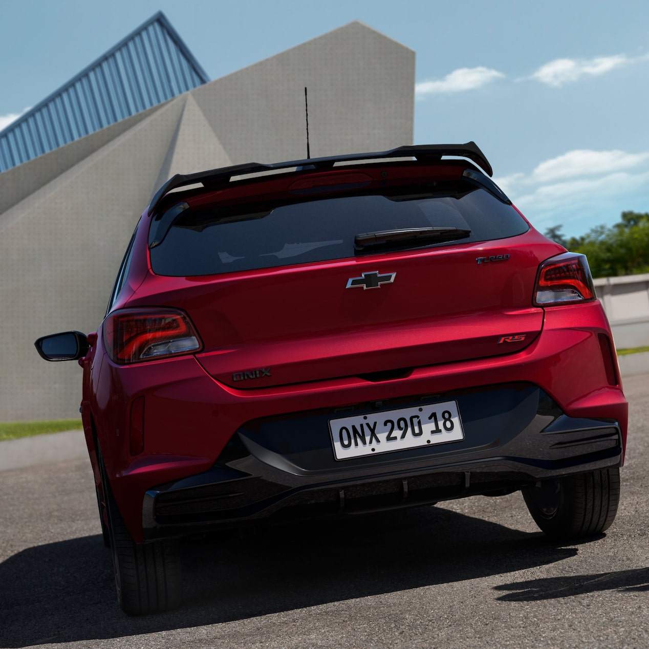 Traseira do Chevrolet Onix RS com lanternas acesas.