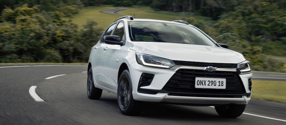 Chevrolet Onix  Activ branco em movimento na estrada com design moderno e faróis LED