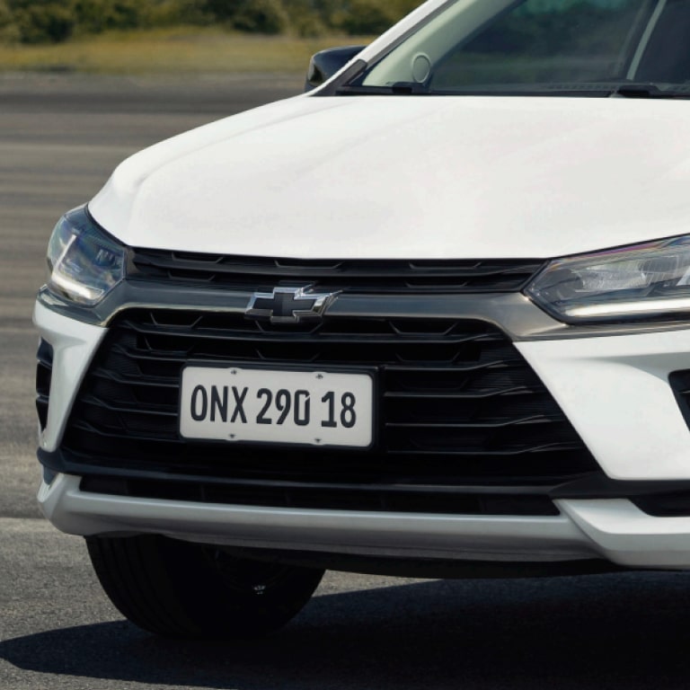 Frontal do Chevrolet Onix Activ branco com grade preta e faróis modernos em destaque