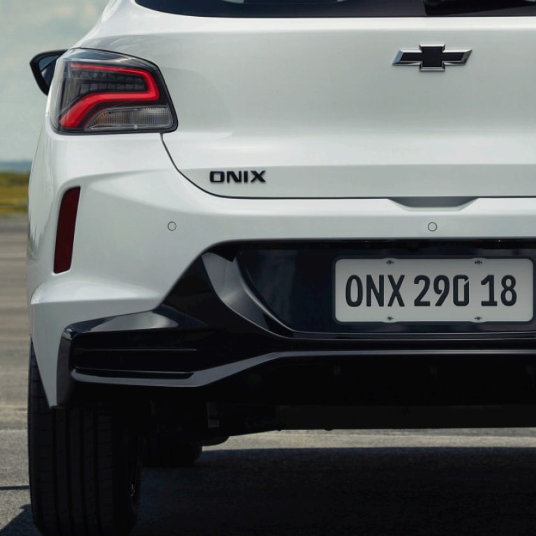 Traseira do Chevrolet Onix Activ branco com emblema Onix e lanterna moderna em destaque