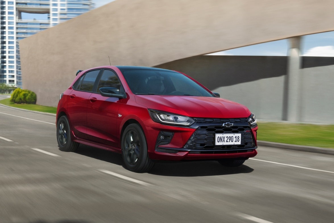 Chevrolet Onix RS Vermelho Scarlet em movimento em via urbana.