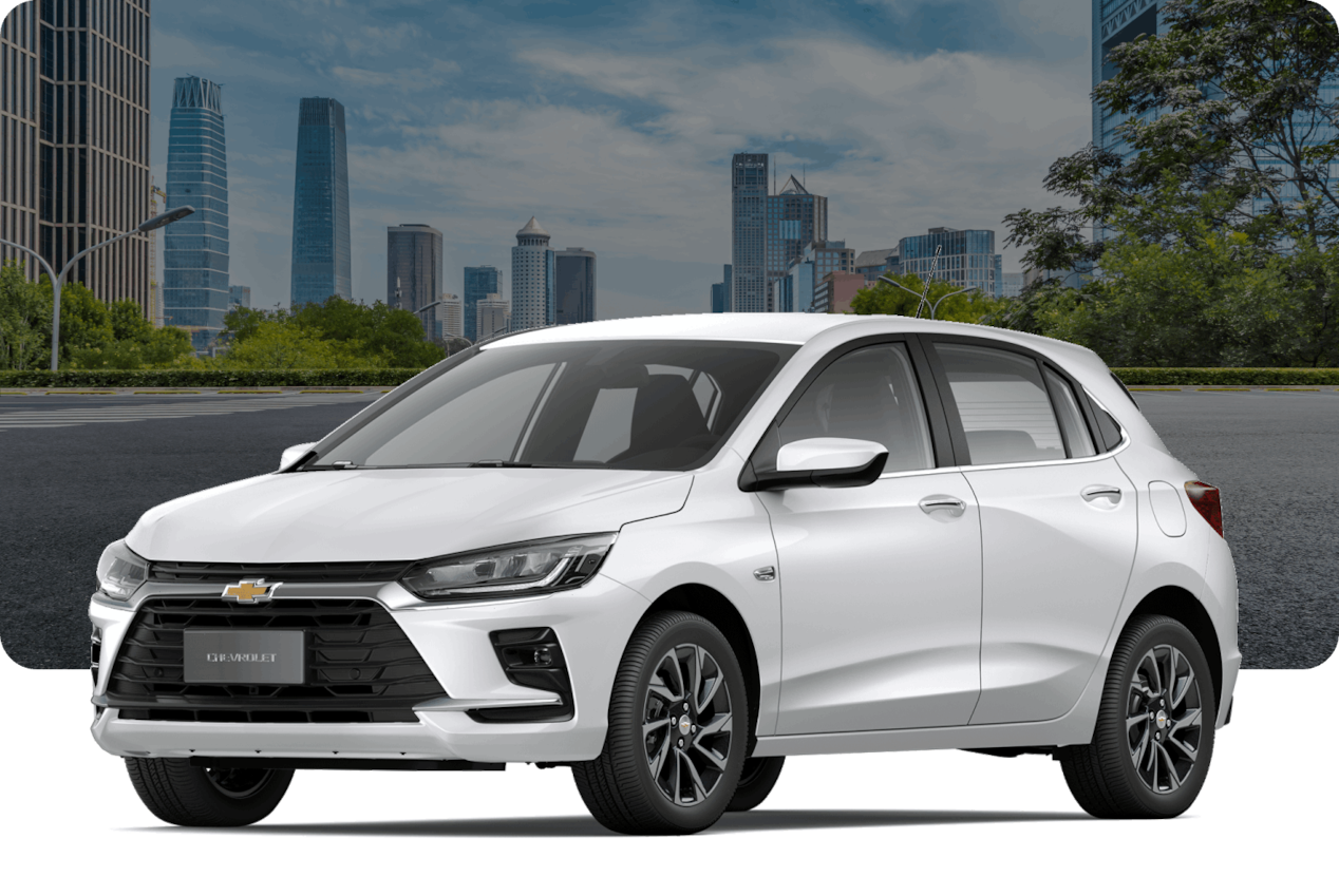 Chevrolet Onix Premier Turbo na cor Branco Summit, em avenida arborizada com skyline ao fundo.