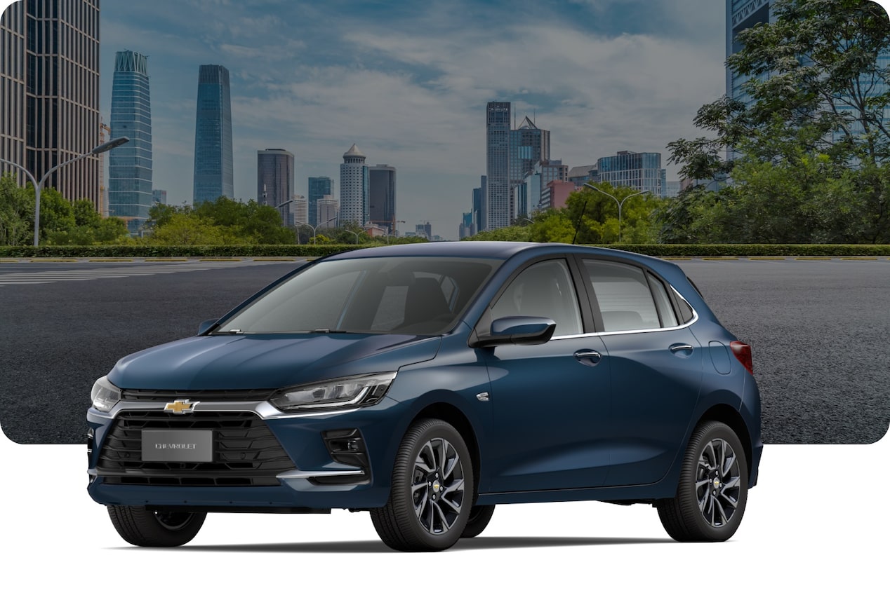 Chevrolet Onix Premier Turbo na cor Branco Summit, em avenida arborizada com skyline ao fundo.