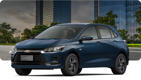 Chevrolet Onix hatch azul Turbo MT / AT em cenário urbano com prédios modernos, carro compacto com design atualizado, faróis LED e transmissão automática.