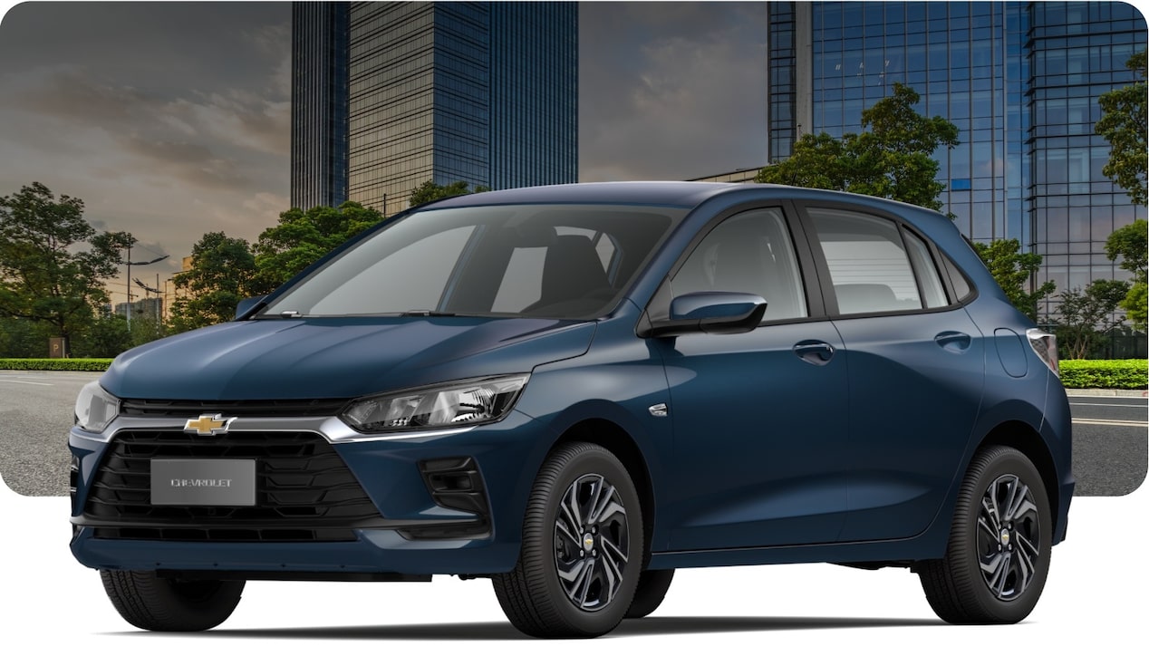 Chevrolet Onix hatch azul Turbo MT / AT em cenário urbano com prédios modernos, carro compacto com design atualizado, faróis LED e transmissão automática.