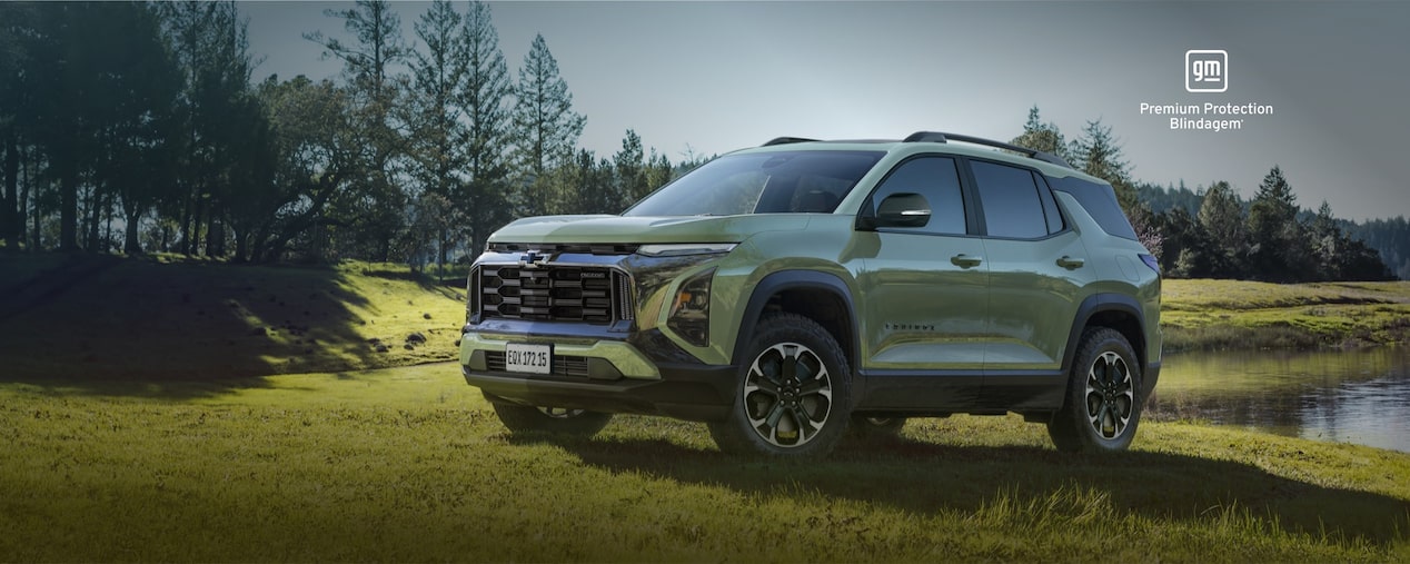 Equinox Turbo Verde Cacti estacionado à beira de um lago. No canto superior direito, o selo GM – Premium Protection Blindagem.