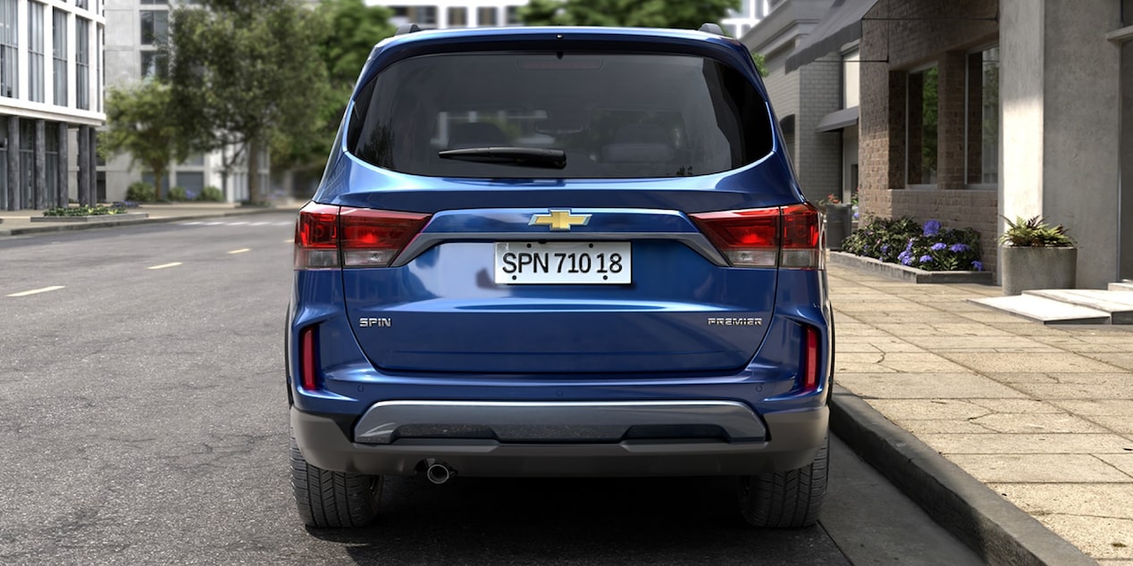 Visão traseira do Chevrolet Spin 2027 em imagem ambientada na rua.