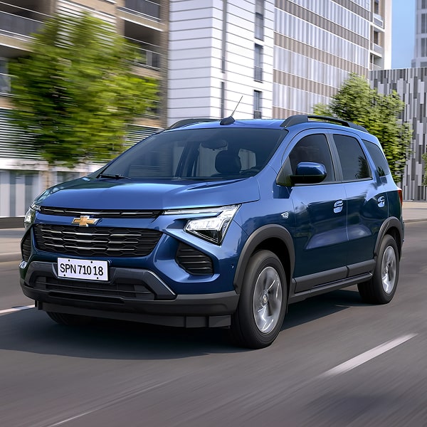 Chevrolet Spin Premier 2027 em foto ambientada na rua para compor o módulo de ofertas. À direita, o carro; a esquerda.