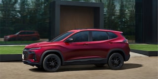 Vista lateral do Chevrolet Tracker RS AT Turbo na cor Vermelho Scarlet, estacionado em ambiente externo.