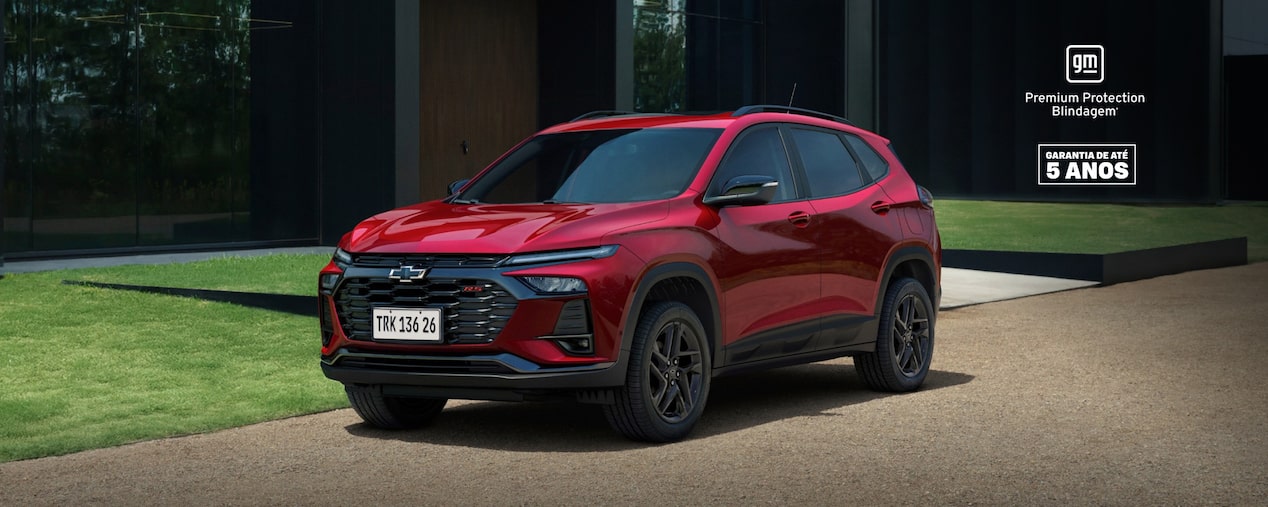Tracker Vermelha estacionada na rua. No canto superior direito, o selo GM – Premium Protection Blindagem.