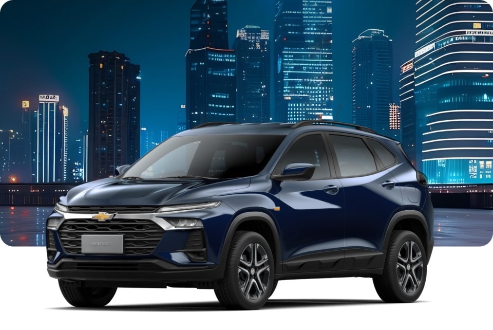 Chevrolet Tracker LT AT Turbo na cor Prata Shark, em ambiente noturno com prédios iluminados.