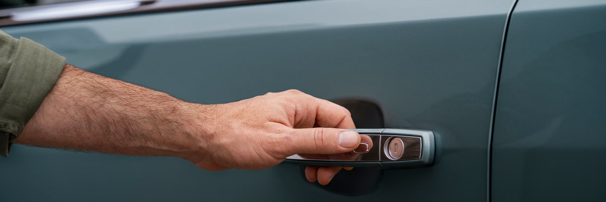 Detalhe da mão de um homem posicionada na maçaneta de um Chevrolet Trailblazer.