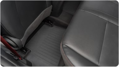 Visão interna do veículo com destaque para o tapete de cabine. Também vemos um pedaço do banco do motorista.