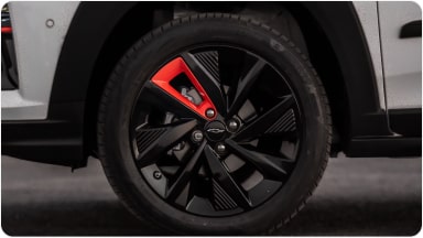Foco na roda do Chevrolet Sonic. Temos um um aplique vermelho na roda, um acessório que adiciona cor da roda do veículo.
