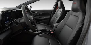 Visão em primeira pessoa do interior do carro. Temos em quadro, o volante e o banco do motorista e passageiro.​
