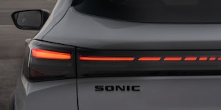 Foco na traseira do Chevrolet Sonic. Destaque as as luzes em LED vermelho e o nome do veículo. ​