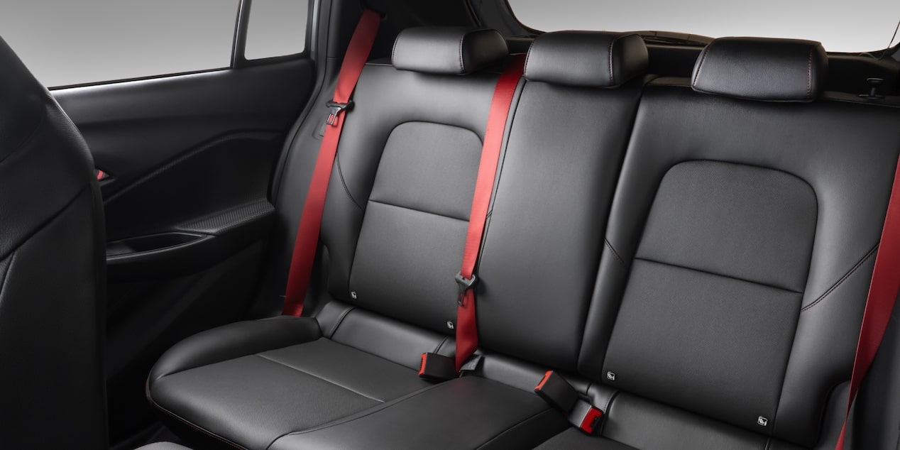 Bancos traseiros do Chevrolet Sonic, com os cintos de segurança em vermelho.​