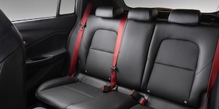 Bancos traseiros do Chevrolet Sonic, com os cintos de segurança em vermelho.​