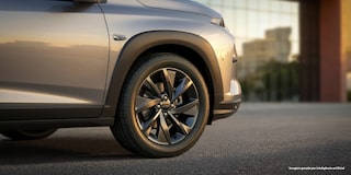 Foco na roda dianteira direita do Chevrolet Sonic. O cenário está em um fim de tarde, dando um tom amarelado para a imagem.​