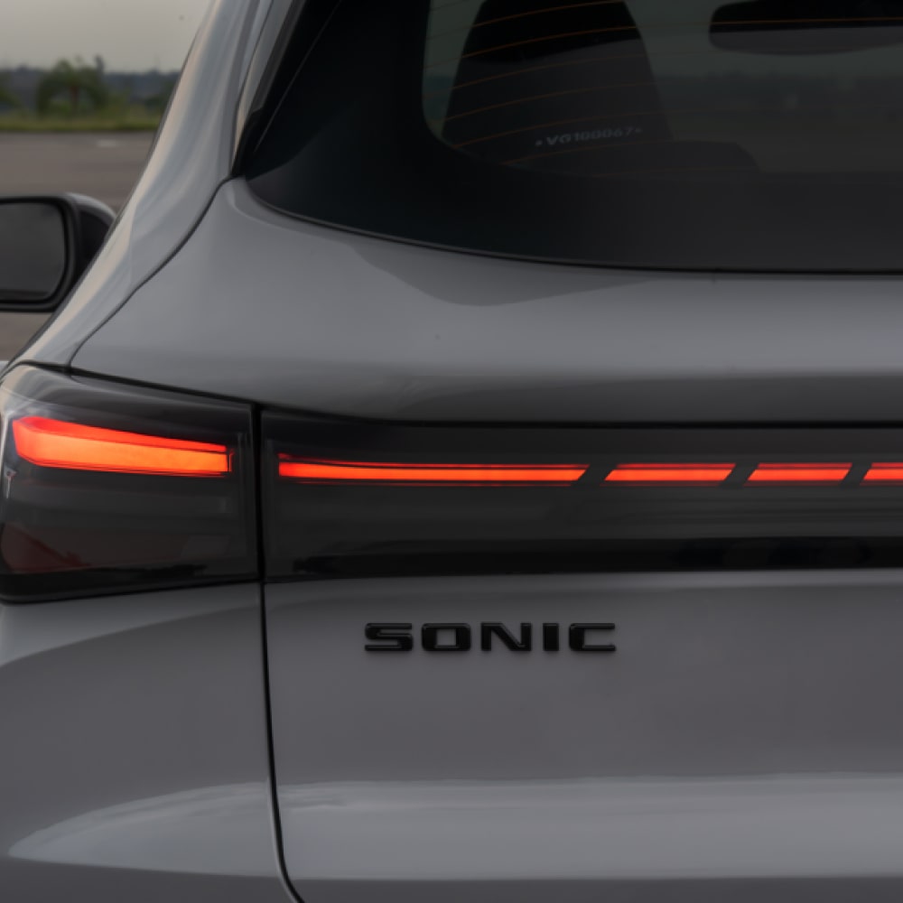 Foco na traseira do Chevrolet Sonic. Destaque as as luzes em LED vermelho e o nome do veículo.