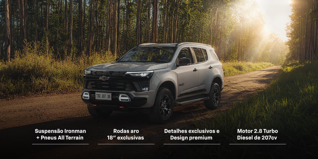 Chevrolet Trailblazer High Country Midnight Edition estacionado em um ambiente externo e em uma estrada de terra. Ao fundo, temos arbustos, plantas e árvores e o Sol de fim de tarde ilumina o carro.