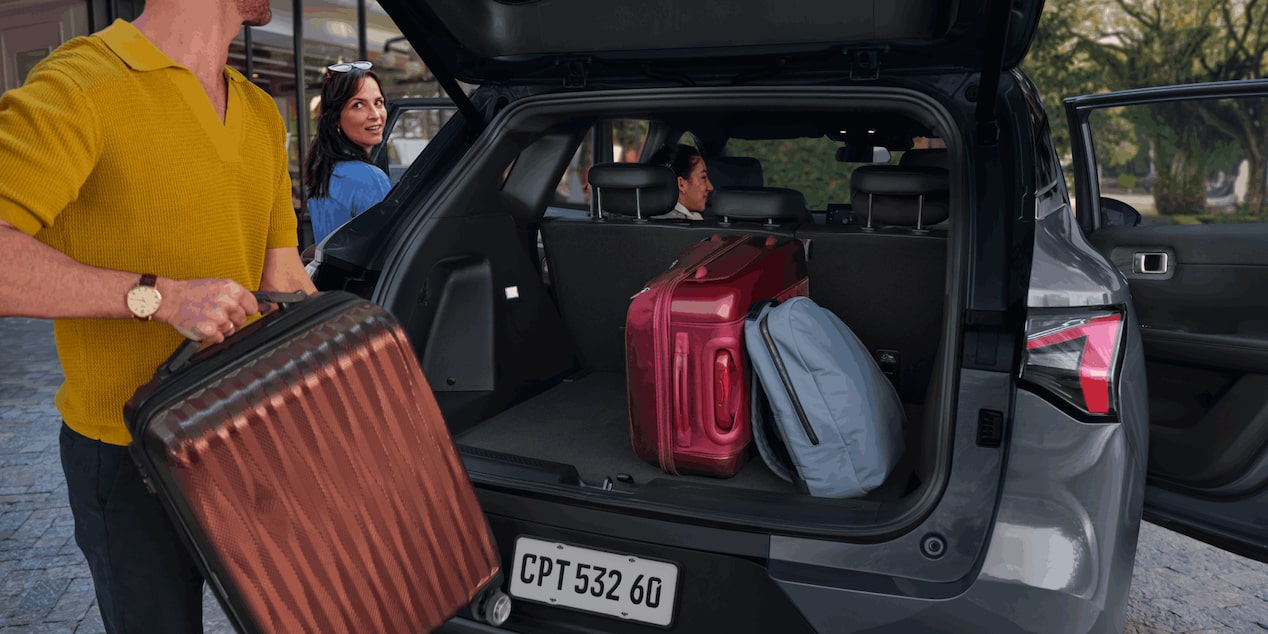 Porta-malas da Captiva EV com malas e mochilas, sendo carregado por uma pessoa.