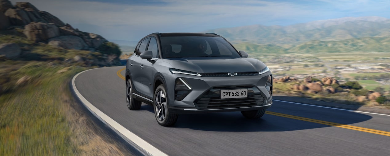 Chevrolet Captiva EV em foto ambientada. O carro aparece em uma estrada. Esta imagem ilustra a sessão de aparência da linha de acessórios originais Chevrolet.